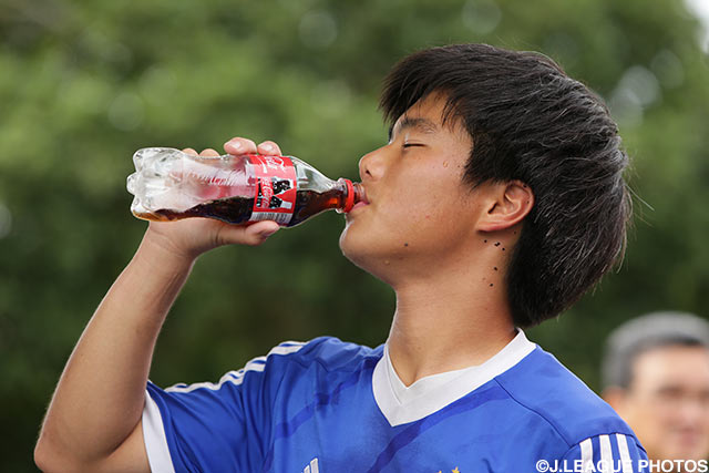 休憩中にコカ・コーラを飲む選手。運動後の味は格別だ