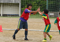 【2015JPFAサッカースクールin南三陸】ハイタッチで喜びを分かち合う佐藤（4/11）
