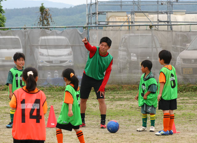【2015JPFAサッカースクールin南三陸】優しくアドバイスを送る武藤（5/11）