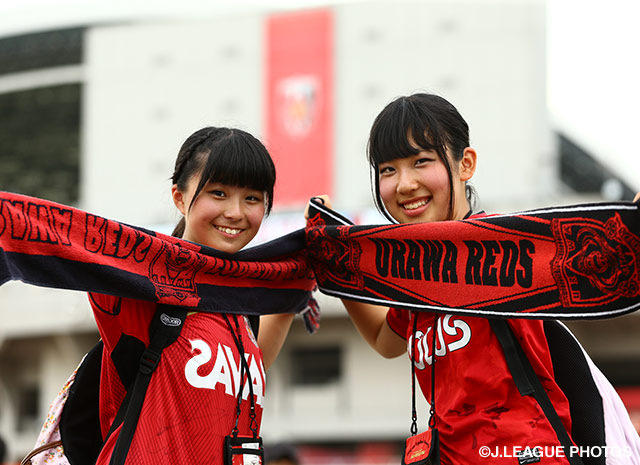 【明治安田Ｊ１ ２ｎｄ 第3節 浦和vs広島】タオルマフラーを持ち笑顔を見せる浦和のファン・サポーター（2/22）