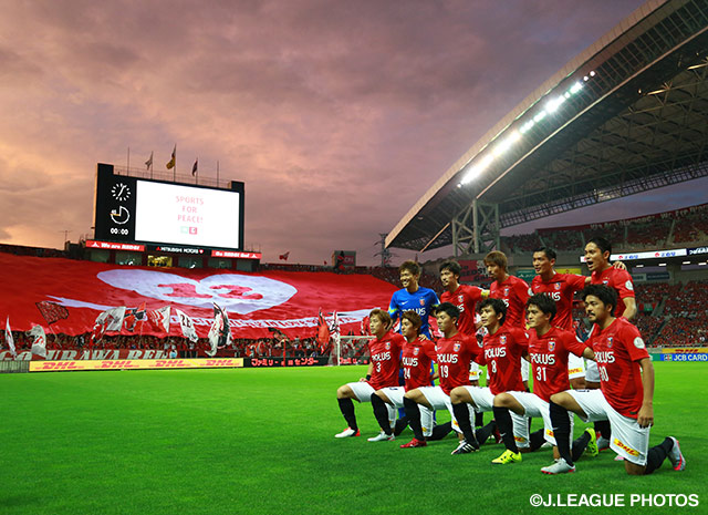 【明治安田Ｊ１ ２ｎｄ 第3節 浦和vs広島】ビッグフラッグを背に集合写真を撮影する浦和の先発メンバー（11/22）