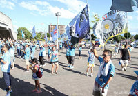 【明治安田Ｊ２ 第26節 讃岐vs北九州】応援旗を高く掲げ、チームのスタジアム入りを迎える讃岐のファン・サポーター（1/4）