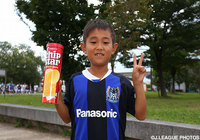 ヤマザキナビスコのチップスターを手にピースサインをつくるＧ大阪ファン・サポーターの少年【ＹＮＣ 準々決勝 第1戦 Ｇ大阪vs名古屋】（1/9）