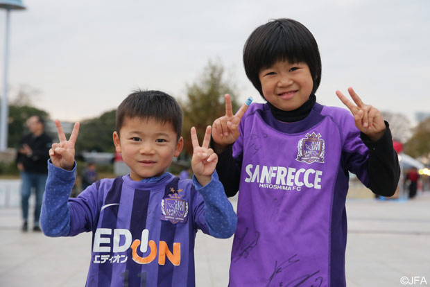 ダブルピースで笑顔を浮かべる広島のちびっこサポーター