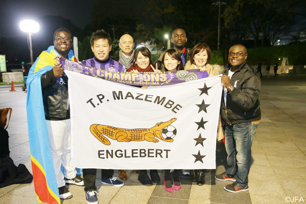 マゼンべと広島、両チームのファン・サポーターが並んで写真を撮る様子