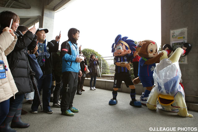 マスコットのパフォーマンスを記念撮影するファン・サポーター