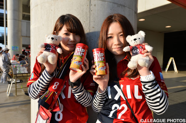 グッズとお菓子を持ってはにかみ笑顔の鹿島女子サポーター【ＹＮＣ GS 第5節 鹿島vs湘南】