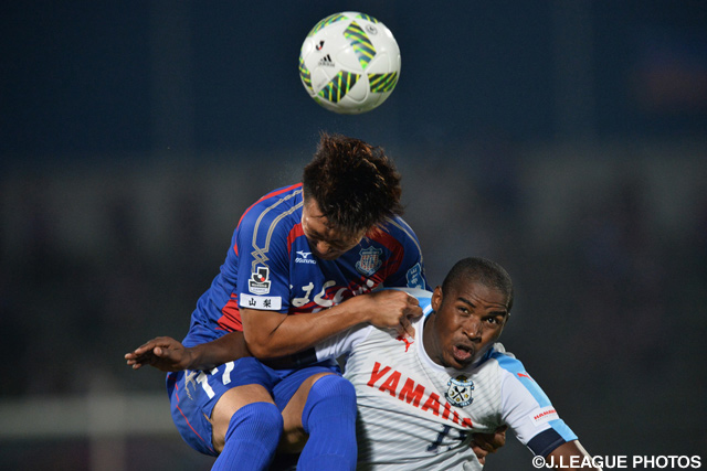 競り合う津田 琢磨（甲府）とアダイウトン（磐田）【明治安田Ｊ１ 2nd 第3節 甲府vs磐田】