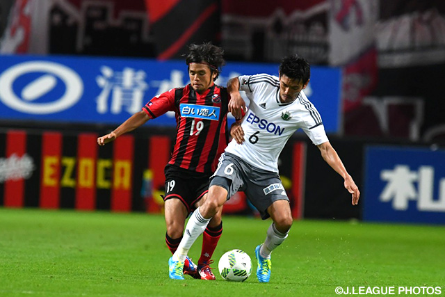 中盤で激しく競り合う石井 謙伍（札幌）と安藤 淳（松本）【明治安田Ｊ２ 第24節 札幌vs松本】