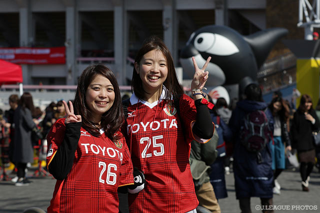 ピースサインをする名古屋のサポーター。背景のグランパス君も存在感十分【明治安田Ｊ２ 第1節 名古屋vs岡山】