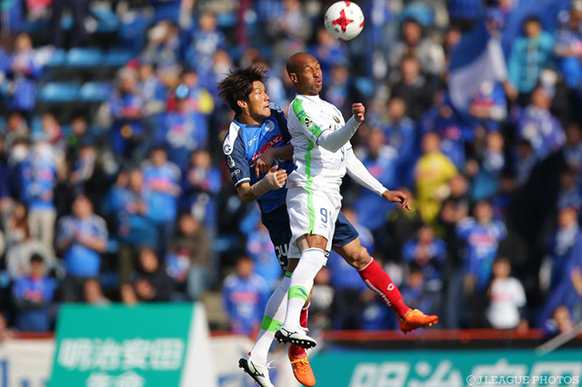 空中で激しく競り合う細川 淳矢（水戸）とジネイ（湘南）【明治安田Ｊ２ 第1節 長崎vs群馬】