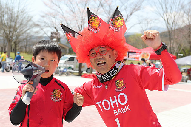 アフロヘアーにフラッグを刺したご機嫌なお父さんと、拡声器を手に気合十分の息子さん【明治安田Ｊ３ 第5節 福島vs相模原】