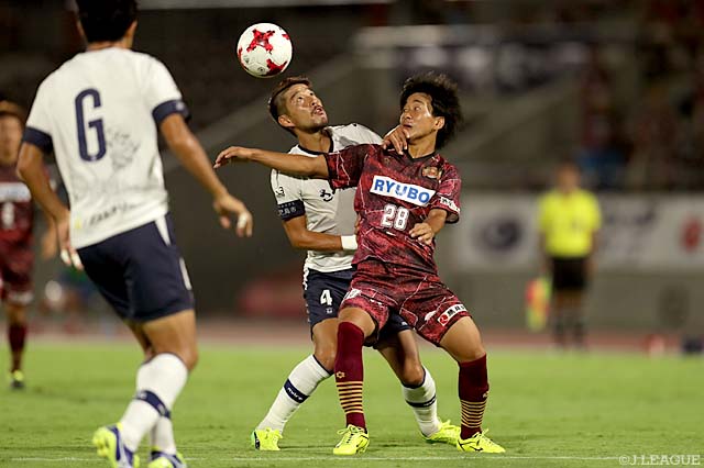 競り合う丹羽 竜平（鹿児島）と名倉 巧（琉球）【明治安田Ｊ３ 第23節 琉球vs鹿児島】