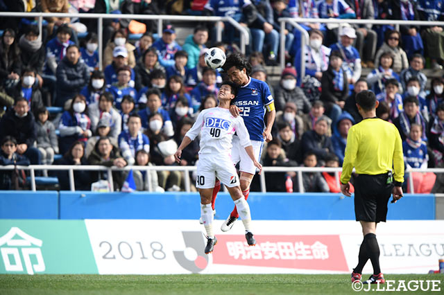 激しい空中戦を繰り広げる小野 裕二（鳥栖）と中澤 佑二（横浜FM）【明治安田Ｊ１ 第3節 横浜FMvs鳥栖】