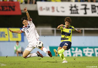 シュートを放つ西谷 優希（栃木）とブロックに入る上田 康太（岡山）【明治安田Ｊ２ 第31節 栃木vs岡山】