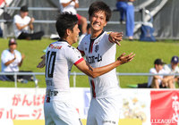 相手のディフェンスラインの裏に抜け出した宮市 剛（右）がスルーパスを受け、右足を振り抜くと、GKに触られるもネットを揺らし岩手が先制【明治安田Ｊ３ 第13節 岩手vs福島】