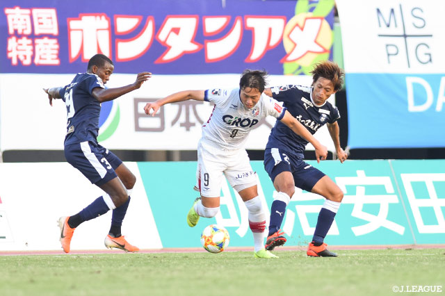 2人の間を強引にドリブル突破を図るイ ヨンジェ（岡山）【明治安田Ｊ２ 第39節 鹿児島vs岡山】