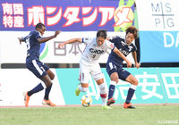 2人の間を強引にドリブル突破を図るイ ヨンジェ(岡山)【明治安田J2 第39節 鹿児島vs岡山】