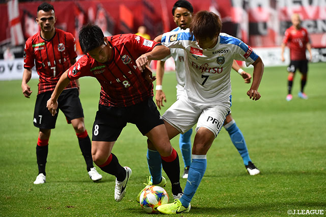 タッチライン際で激しいボールの奪い合いを見せる深井 一希（札幌）と車屋 紳太郎（川崎Ｆ）【明治安田Ｊ１ 第34節 浦和vsＧ大阪】