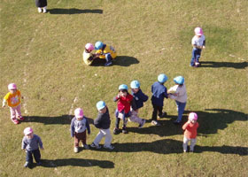 芝生の庭園で遊ぶ園児たち